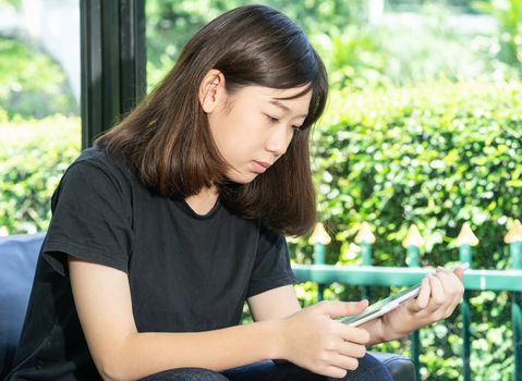 Student teenage studying online from digital tablet on the sofa at home