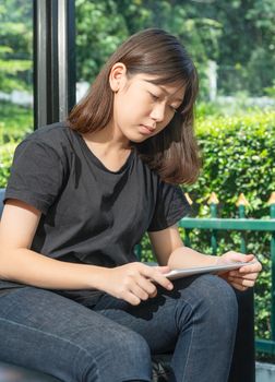 Student teenage studying online from digital tablet on the sofa at home