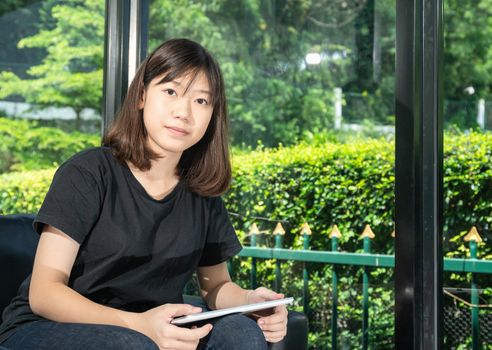 Student teenage studying online from digital tablet on the sofa at home