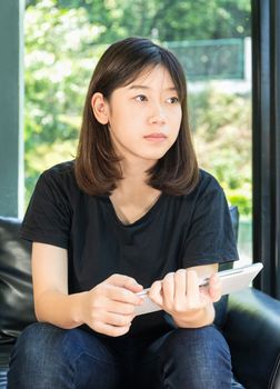 Student teenage studying online from digital tablet on the sofa at home