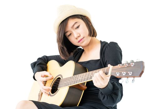 Young asia woman sitting and playing guitar guitar folk song in her hand isolate on white background