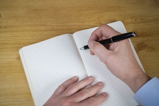 a man writing in a squared notebook