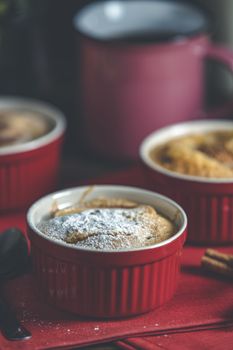 Apple pie in ceramic baking molds ramekin on dark red napkin. Close up, shallow depth of the field.	