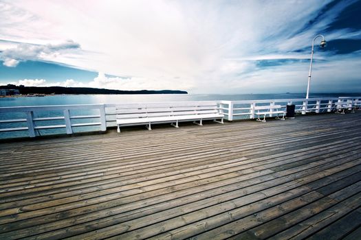 White bench on wooden pier in Sopot, Poland. Jetty on the water. Baltyk sea.