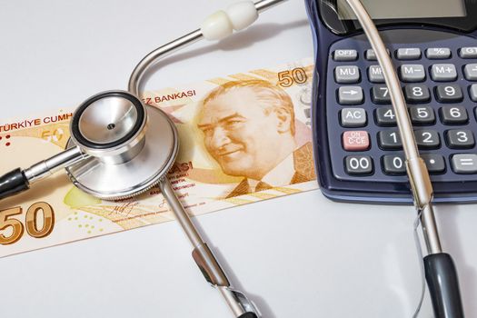 close up currency paper banknote on white background with stethoscope and calculator.