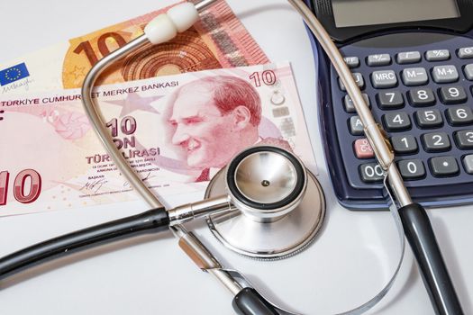 close up currency paper banknote on white background with stethoscope and calculator.