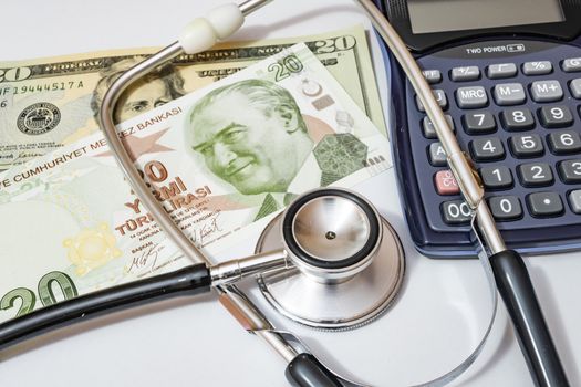 close up currency paper banknote on white background with stethoscope and calculator.
