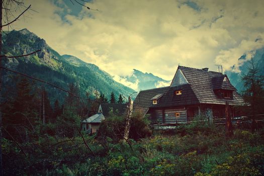 Nature in mountains. Old wooden house in beautiful mountains scenery. Vintage picture.