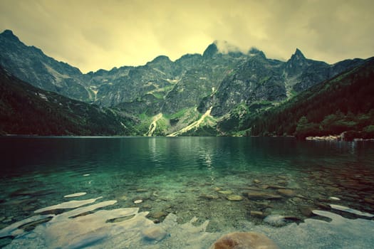 Lake in mountains. Fantasy and colorfull nature landscape. Retro vintage picture.