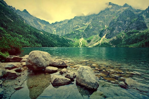 Lake in mountains. Fantasy and colorfull nature landscape. Retro vintage picture.