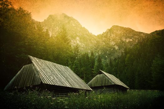 Small wooden houses under mountain. Nature in mountains. Grunge picture of Giewont.