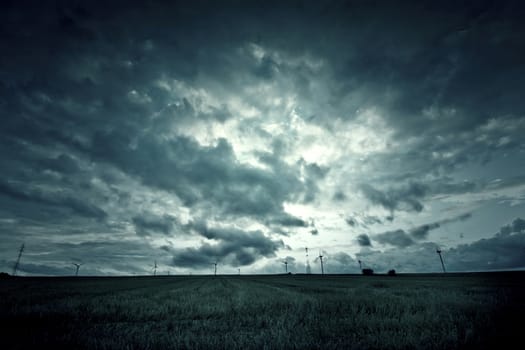 Dark sky with clouds over field. Nature landscape.