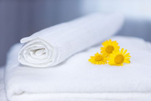 Three yellow flowers on folded towels and backlight