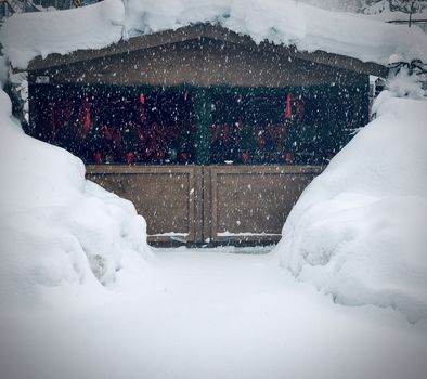 Decorated house covered with snow in a snowy day in December. Holiday season concept. 