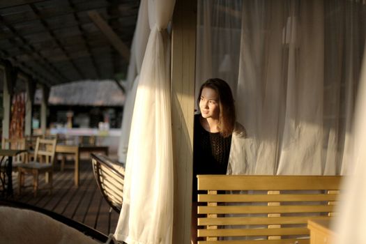 portrait of young girl in black jacket sweater at sunset, summer interior