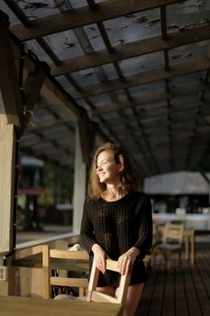 portrait of young girl in black jacket sweater at sunset, summer interior