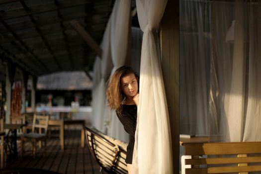 portrait of young girl in black jacket sweater at sunset, summer interior