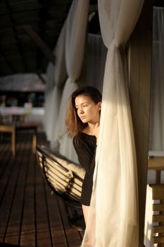 portrait of young girl in black jacket sweater at sunset, summer interior