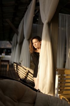 portrait of young girl in black jacket sweater at sunset, summer interior