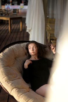 portrait of young girl in black jacket sweater at sunset, summer interior