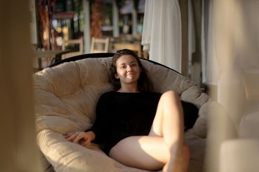 portrait of young girl in black jacket sweater at sunset, summer interior