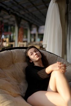 portrait of young girl in black jacket sweater at sunset, summer interior