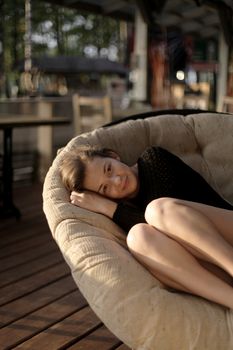 portrait of young girl in black jacket sweater at sunset, summer interior