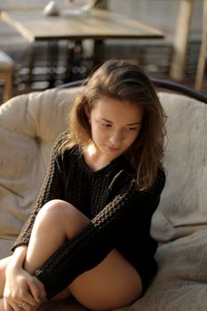 portrait of young girl in black jacket sweater at sunset, summer interior