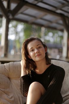 portrait of young girl in black jacket sweater at sunset, summer interior