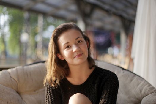 portrait of young girl in black jacket sweater at sunset, summer interior