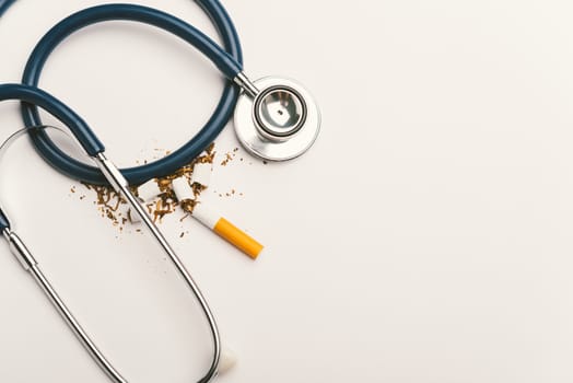 31 May of World No Tobacco Day, no smoking, close up of broken pile cigarette or tobacco and doctor stethoscope on white background with copy space, and Warning lung health concept