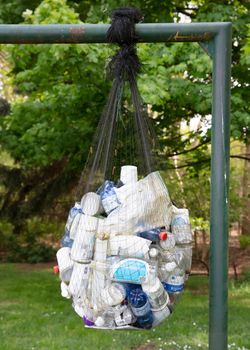 Coevorden, the Netherlands on may 3, 2020; A black net filled with gathered plastic bottles.
