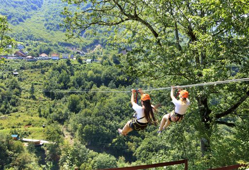 Girls on the cable car are sent through the mountain and the forest through the valley of the river Tiara in Montenegro.