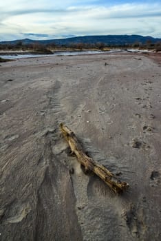 Cracked red clay and white salt on the surface in a dried riverbed in the desert of New Mexico, USA