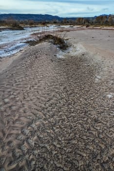 Cracked red clay and white salt on the surface in a dried riverbed in the desert of New Mexico, USA