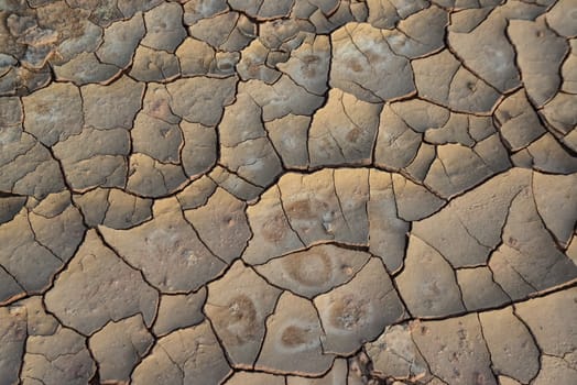 Cracked red clay and white salt on the surface in a dried riverbed in the desert of New Mexico, USA