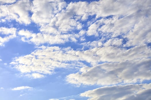 Light blue sky with white and gray fluffy clouds.