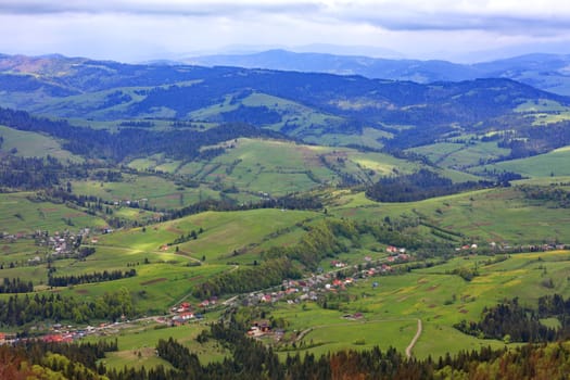 Mountain landscape with a view of the village and ski lift in the spring from a mountain peak, nature in the Carpathian mountains.