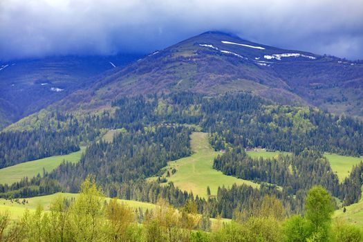 The landscape of the Carpathian mountains whose peaks are shrouded in dense fog in early spring.