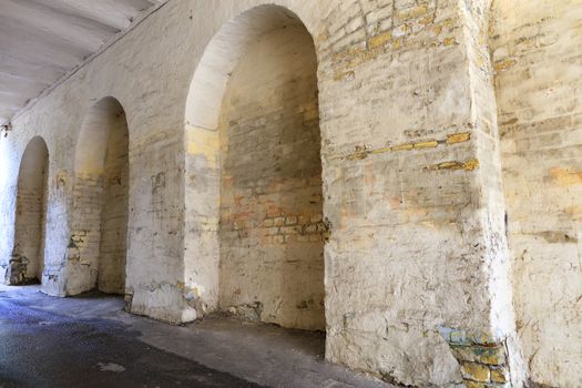 Arched niches in the old kirichnaya wall of the house, covered with weathered paint and patched plaster.