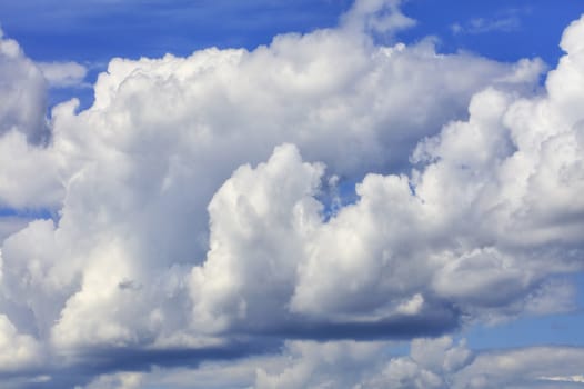 In the blue sky, white-gray fluffy clouds gradually come together before the rain.
