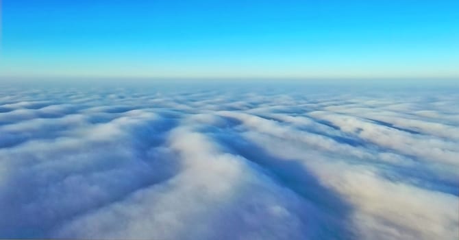 Aerial photographs, bright sunlight falls on dense gray clouds in blurry spots, a photograph about 500 meters high, taken with the latest generation of a drone from a drone.