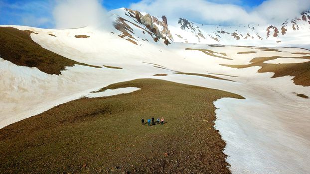 Aerial photographs, bright sunlight falls on a group of tourists who are in a rocky meadow at the foot of Erciyes Mountain in central Turkey, a photograph about 200 meters high, made using a drone.