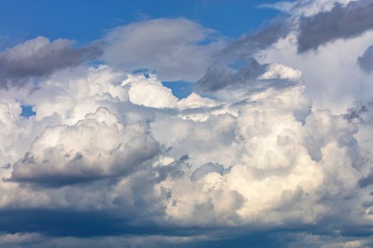 White-gray cumulus clouds gradually gather together into one continuous cover in anticipation of rain.