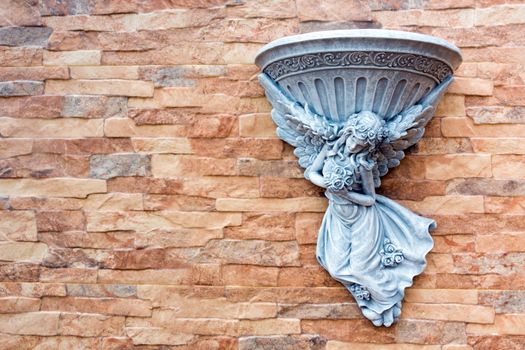 Fairy statue and fountain basin decorated on the wall