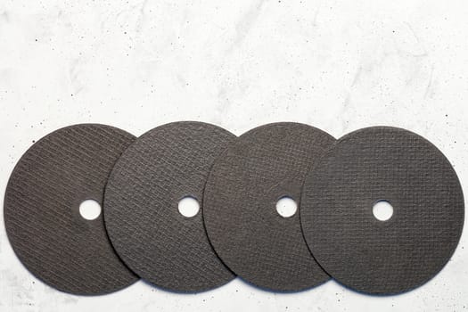 Set of cutting abrasive disc for cutting of the metal on the gray concrete close-up, image with copy space.