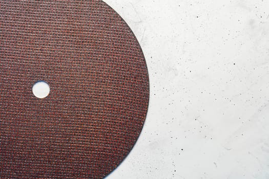 Segment semicircle of abrasive disc on a background of gray concrete close-up, image with copy space.