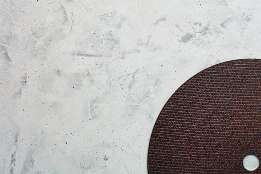 Segment of a diamond blue cutting disc on a background of gray concrete close-up, image with copy space.