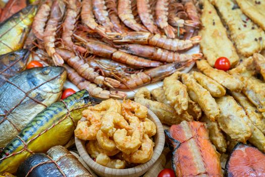 Smoked fish at the store counter. Seafood sale. Shrimp and fish in a shop window.