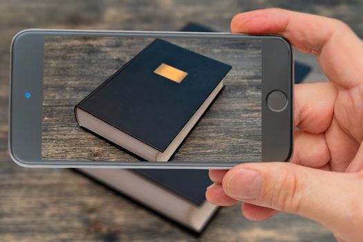 Book on smartphone screen. Big fat book. Knowledge is written in books. Training, education and storage of information.